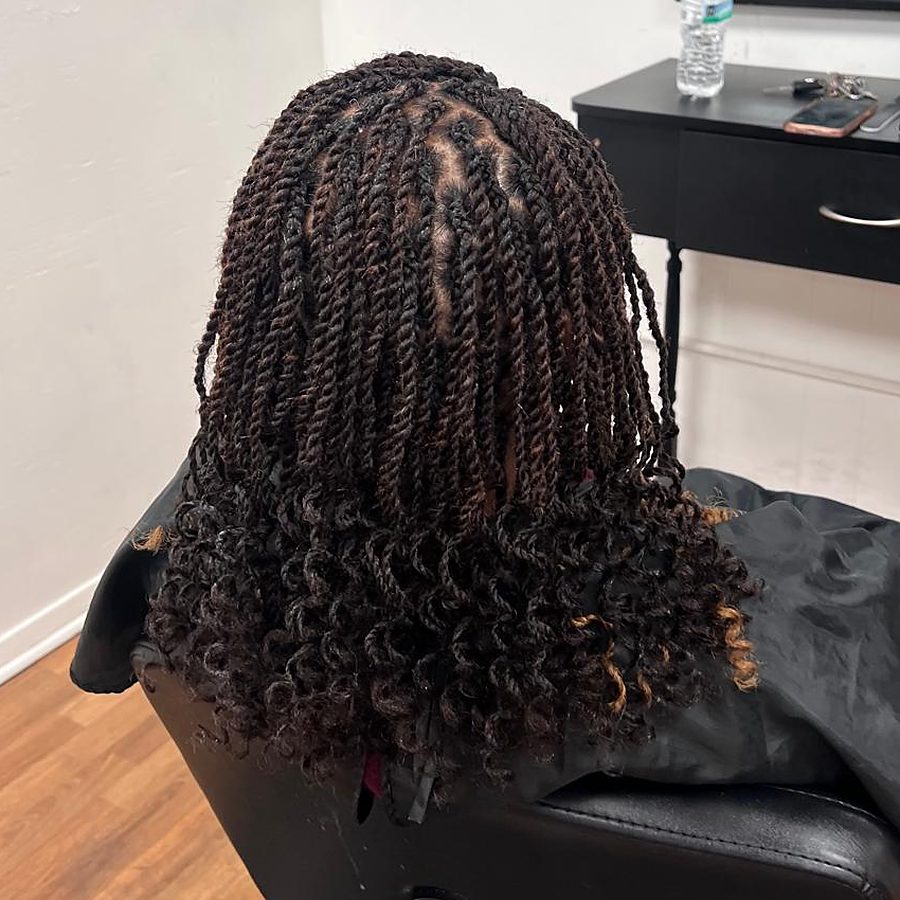 Photo from Lyn African Hair Braiding's own Google Business Profile: twists finished with curled ends, seen from behind in the shop chair.
